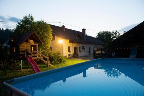 a house with a swimming pool in front of a house at Apartma Marija in Metlika