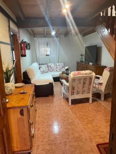 ein Wohnzimmer mit einem weißen Sofa und Stühlen in der Unterkunft Casa Mariyina in Ribadesella
