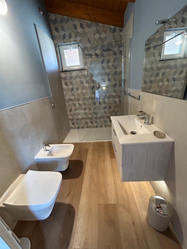 a bathroom with two sinks and a toilet in it at Ferdinando’s House in Pozzomaggiore