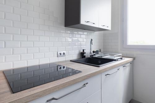 une cuisine avec un évier et un plan de travail dans l'établissement Mat&Ness Appartment, à Beauvais