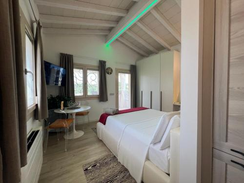 a bedroom with a large white bed and a table at Antica Fonte Holiday Homes in San Pantaleo