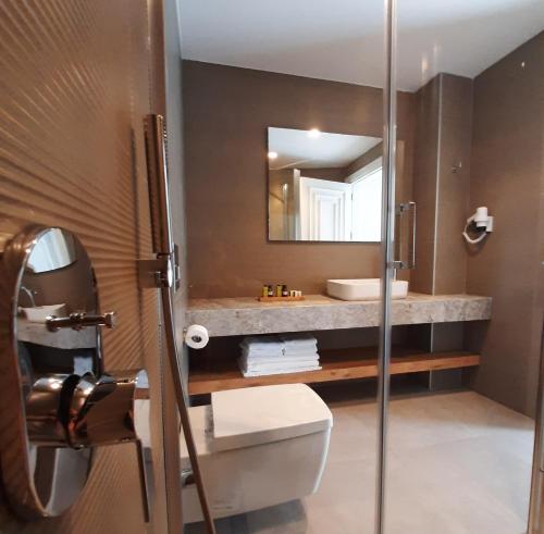 a bathroom with a sink and a toilet and a mirror at Nilus Boutique Hotel in Urla