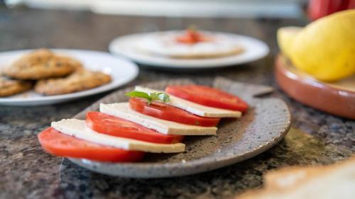 a plate of food with tomatoes and cheese on it at Casa Samai Boutique in Samaipata