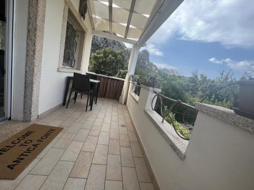 a balcony with a table and a view of the mountains at Antica Fonte Holiday Homes in San Pantaleo