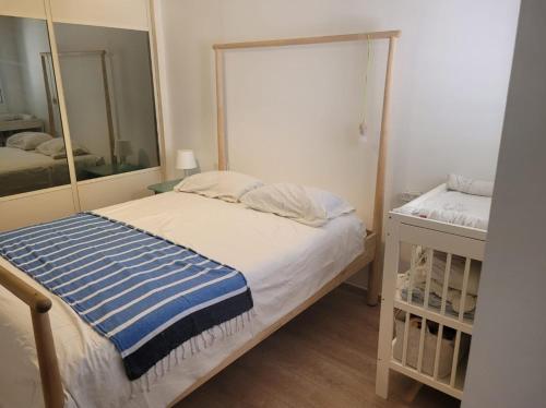 um pequeno quarto com uma cama e um espelho em הבית באשכולות em Ma'alot-Tarshiha