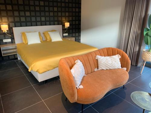 una camera con letto, divano e sedia di Q Guesthouse a Herzele