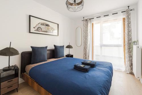 馬尼庫爾勒翁格爾的住宿－Cosygreen77 Disneyland Paris Modern Apartment with garden & parking，一间卧室配有一张带蓝色床单的床和一扇窗户。