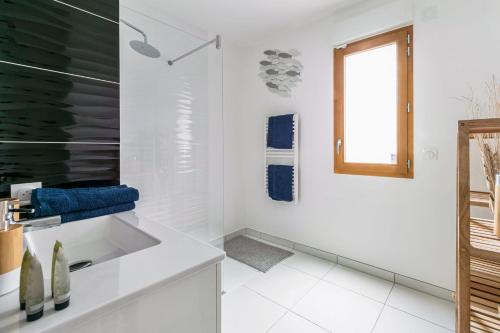 a white bathroom with a sink and a window at Cosygreen77 Disneyland Paris au calme avec jardin in Magny-le-Hongre
