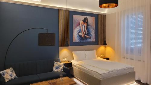 a bedroom with a bed and a couch in it at Glamour Apartman in Gyula