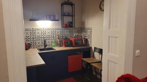 a small kitchen with a counter and a microwave at Glamour Apartman in Gyula