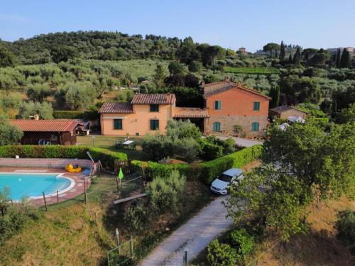 a house with a car parked next to a swimming pool at La Piaggiola degli Olivi in Panicale