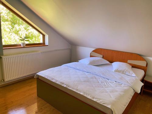 - une chambre avec un lit doté de draps blancs et une fenêtre dans l'établissement Roua Muntelui, à Sărata-Monteoru