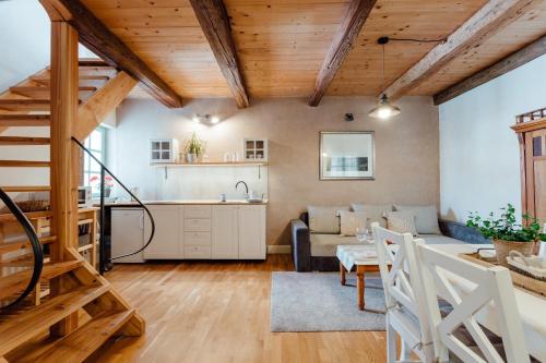 バンスカー・シュチャヴニツァにあるDobré časy - Rodinný apartmán III.のキッチン、木製の天井と階段のあるリビングルーム