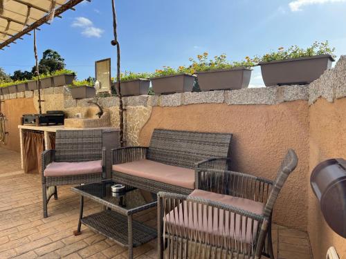 a patio with chairs and a table and a counter at Antica Fonte Holiday Homes in San Pantaleo