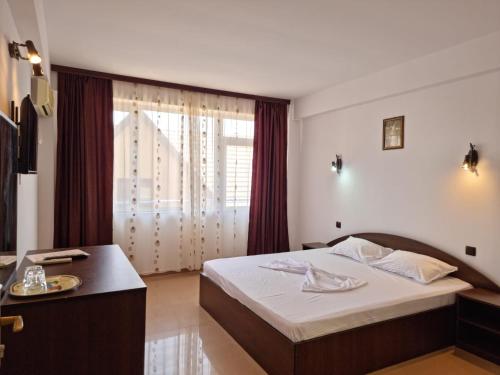 a hotel room with a bed and a window at Harmony Villa in Costinesti