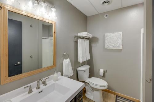 ein Badezimmer mit einem Waschbecken, einem WC und einem Spiegel in der Unterkunft Modern Yankton Apartment Near Riverside Park! in Yankton