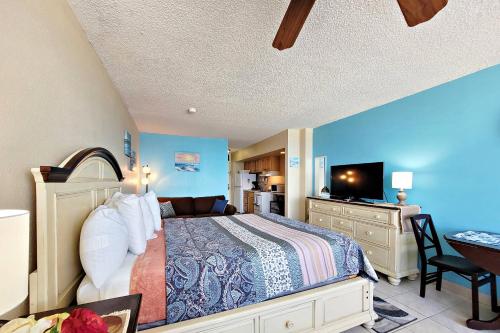 a bedroom with a bed and a desk with a television at Pirates Cove Condo Unit #209 in Daytona Beach