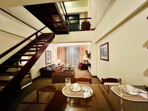 a living room with a table and a staircase at Miraflores Confort Suite in Lima