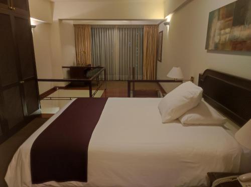 Un pat sau paturi într-o cameră la Miraflores Confort Suite