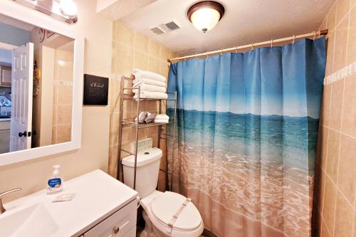 y baño con aseo y cortina de ducha. en Pirates Cove Condo Unit #209 en Daytona Beach