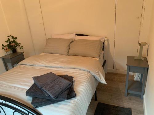 a bed with two towels on it in a room at Alpha house in London