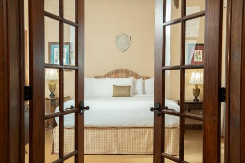 a bedroom with a white bed and a mirror at Hotel Viata in Austin