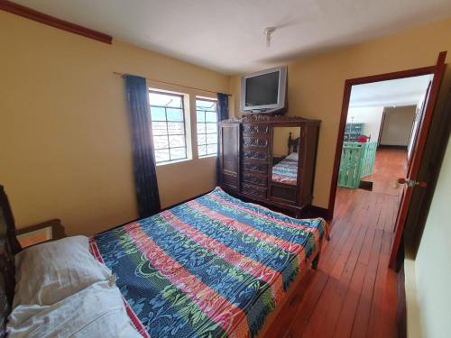 a bedroom with a bed and a tv and a mirror at Hostal la Casa del Músico in El Cocuy