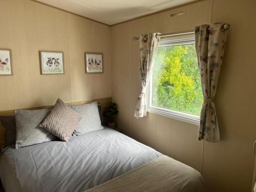 1 dormitorio con cama y ventana en Forest beach Shorefield Park, en Lymington