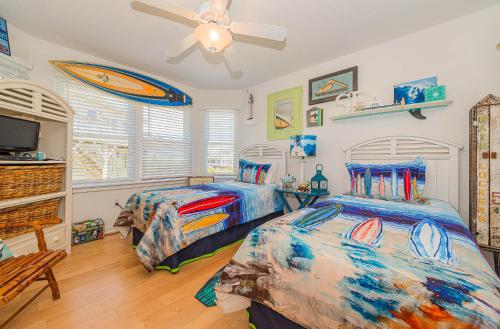 a bedroom with two beds and a ceiling fan at Simple Gifts by the Sea in Duck