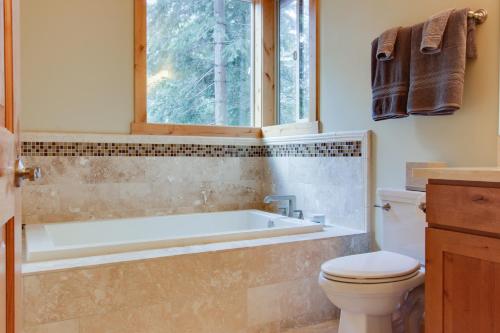 a bathroom with a tub and a toilet and a window at Tahoma Deluxe Brand New Home in Tahoma