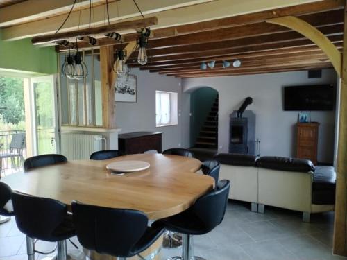a dining room with a wooden table and chairs at Maison de campagne avec piscine in Parigny-les-Vaux