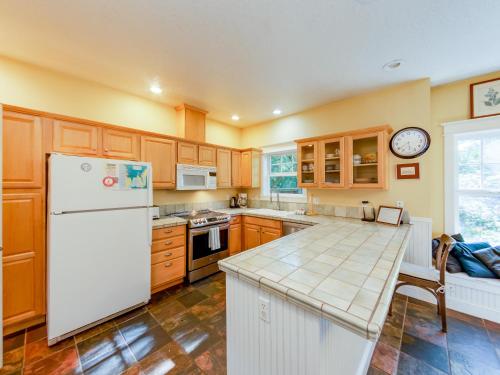 a kitchen with wooden cabinets and a white refrigerator at Bella Mar in Nehalem