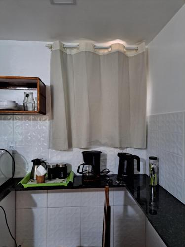 a kitchen with a black counter top and a window at Recanto das Flores Lofts - Ilha Grande Rj in Abraão