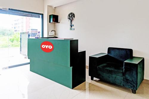 a chair sitting next to a booth with aoops sign at OYO Flagship Night Quine Guest House in Pānchuria