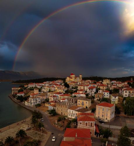 a rainbow in the sky over a city at Penny's Beach Cottage in Galaxidi