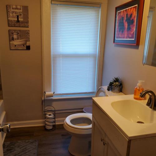 a bathroom with a toilet and a sink and a window at Relaxing Stay Near the Beach in Hampton