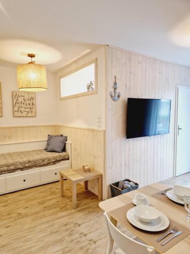 a living room with a bed and a table with chairs at PBA Stockholm - basen kryty, parter, taras, parking in Pobierowo