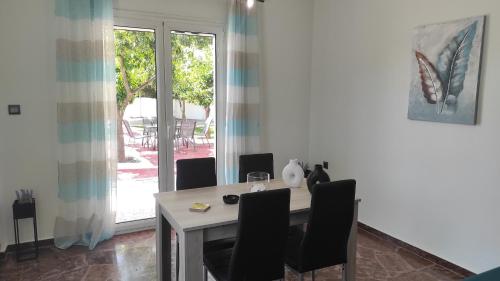 a dining room with a table and chairs and a window at City Apartment w3 BR spacious yard in Eretria