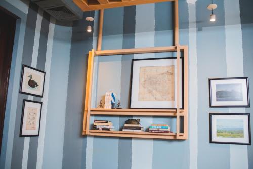 a shelf on a wall with pictures and books at Hotel Los Portales in Chinandega
