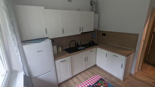 a small kitchen with white cabinets and a sink at Zielono mi....... in Jelenia Góra