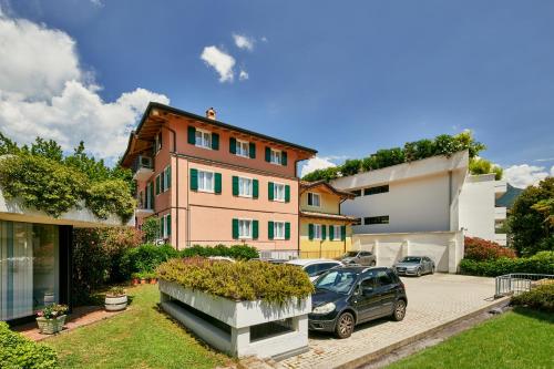 ein Gebäude mit einem Auto auf einem Parkplatz in der Unterkunft Bella Villa Apartments in Riva del Garda