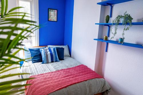 Un dormitorio con una cama con paredes azules y una planta en 6bd Home-Contractors A+ Location en Sheffield