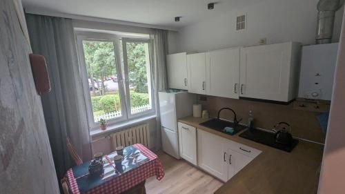 eine Küche mit einem Tisch, einem Waschbecken und einem Fenster in der Unterkunft Zielono mi....... in Jelenia Góra