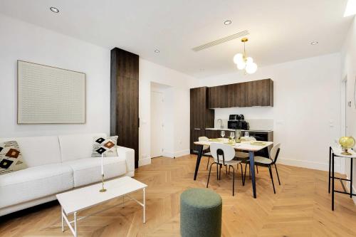 un salon avec un canapé blanc et une table dans l'établissement Luxury apartment 1BR 4P - Opera, à Paris