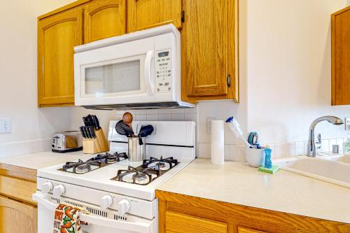 a kitchen with a white stove and a microwave at La Cana Street Leisure - Main Home in Coupeville