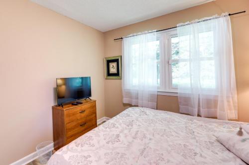 a bedroom with a bed and a tv and a window at Cozy North Carolina Retreat Near Beaches and Golfing in Jacksonville