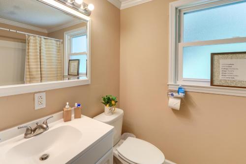 a bathroom with a sink and a toilet and a window at Cozy North Carolina Retreat Near Beaches and Golfing in Jacksonville