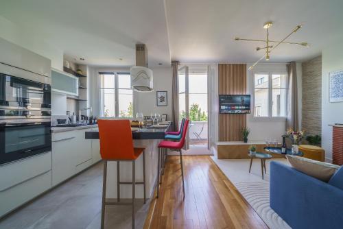 a kitchen and living room with a counter and chairs at Le Balcon des Arts - PrestiPlace Tours in Tours