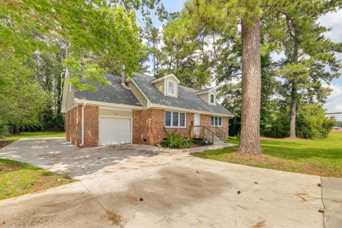 a brick house with a garage and a tree at Cozy North Carolina Retreat Near Beaches and Golfing in Jacksonville