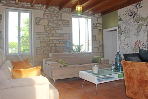 ein Wohnzimmer mit Sofas und einer Steinmauer in der Unterkunft Domaine de KIBA - Maison de Maitre in Barzan